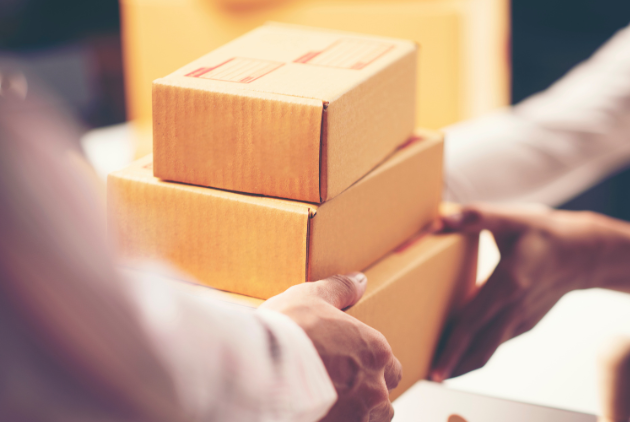 Person handing over packages in a delivery or shipping process, focusing on logistics and fulfillment.